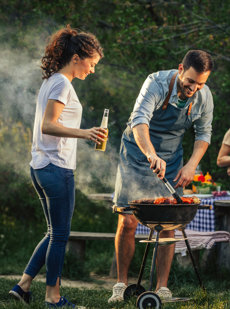 grupo-amigos-felices-haciendo-barbacoa-al-aire-libre